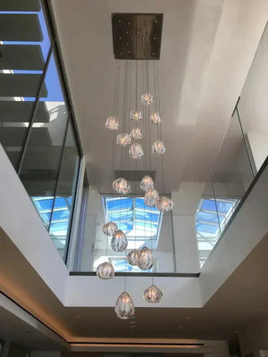 Glass cluster chandelier suspended below a skylight in a modern two-story foyer