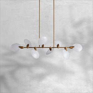 Lyla linear chandelier unlit, showing natural white alabaster discs and brass arms