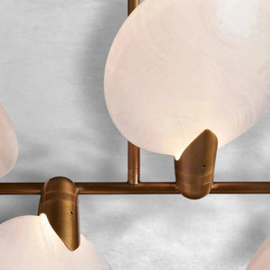 Close-up of Lyla chandelier aged brass fittings holding an alabaster petal shade