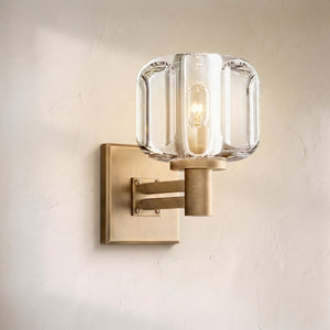 Delume sconce, thick cut-glass shade on an antique brass square backplate with an exposed filament bulb