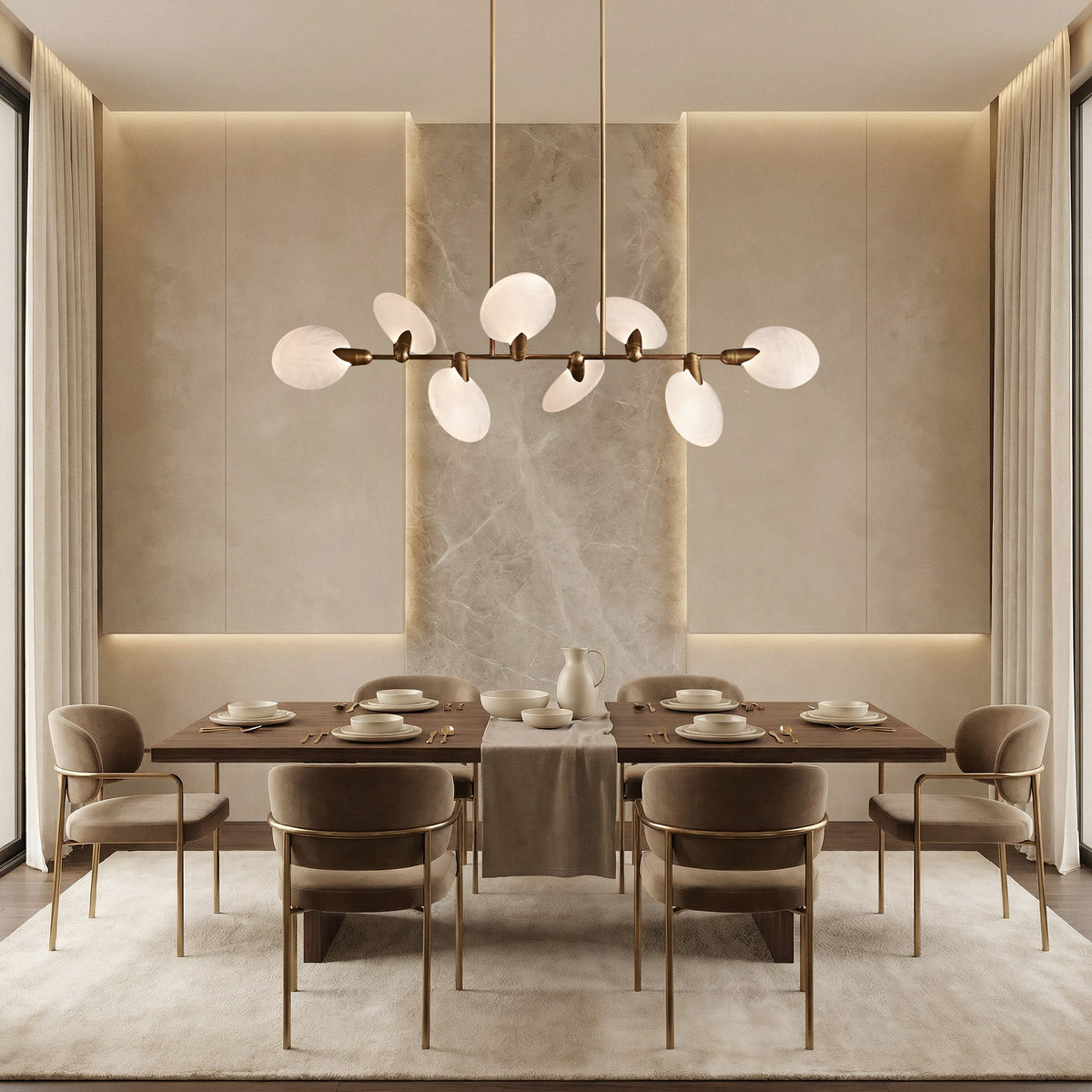 Lyla brass linear chandelier with alabaster petals above a beige dining table with marble accent wall