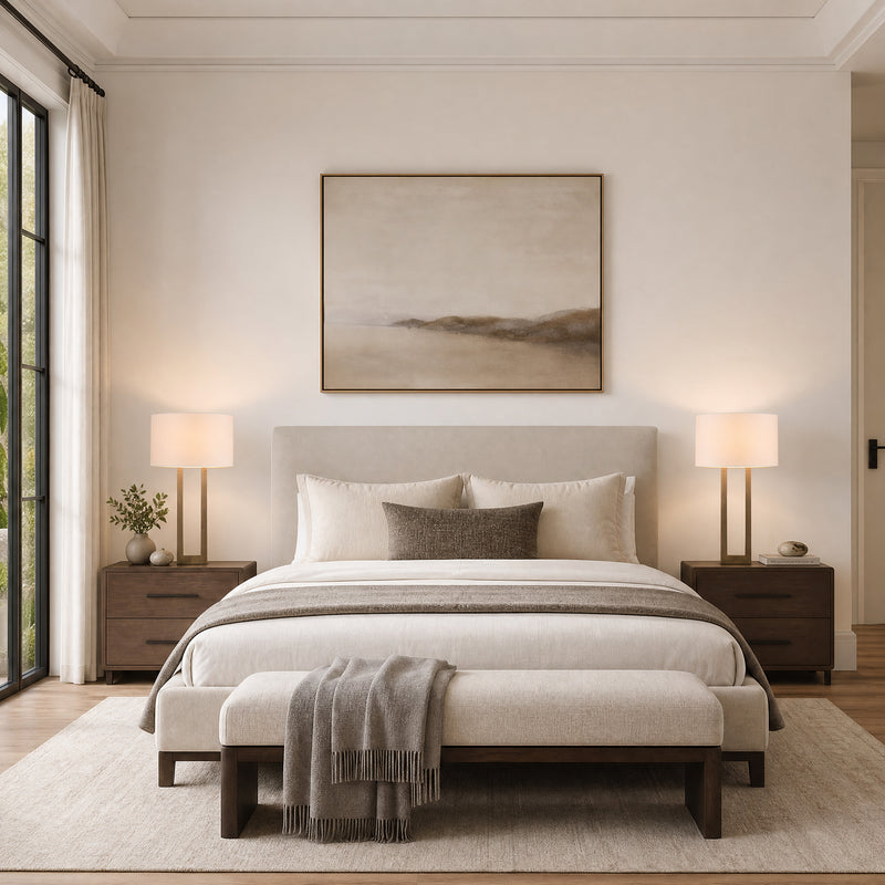 Neutral bedroom with an upholstered bed and a matching pair of brass table lamps with drum shades