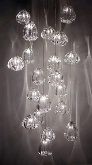 Ribbed glass teardrop pendants casting light patterns on a dark wall