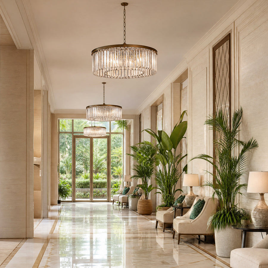 Hotel corridor lounge with cream armchairs, palms and three tiered crystal drum chandeliers