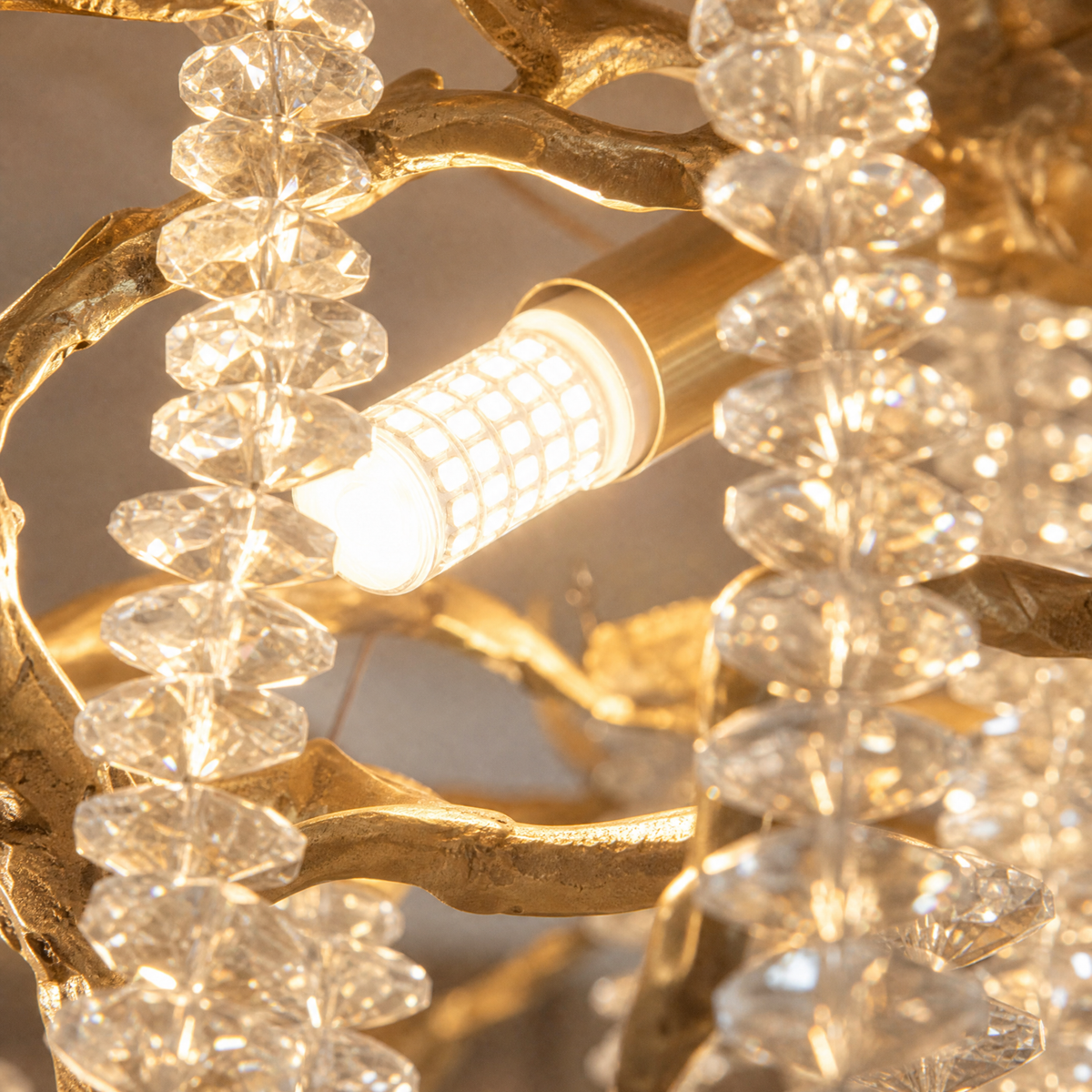 A Yiosi gold metal branch chandelier with cascading crystal beads suspended in a rainfall arrangement.