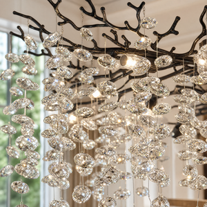 A modern matte black metal branch chandelier adorned with cascading clear crystal drops in a circular shape.