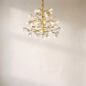Amos glass branch chandelier above a sofa, gilded branches set with raw clear glass nuggets