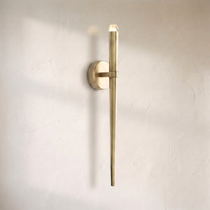 Aurelin modern torch wall sconce, tapered brass rod with a faceted crystal tip on a round backplate