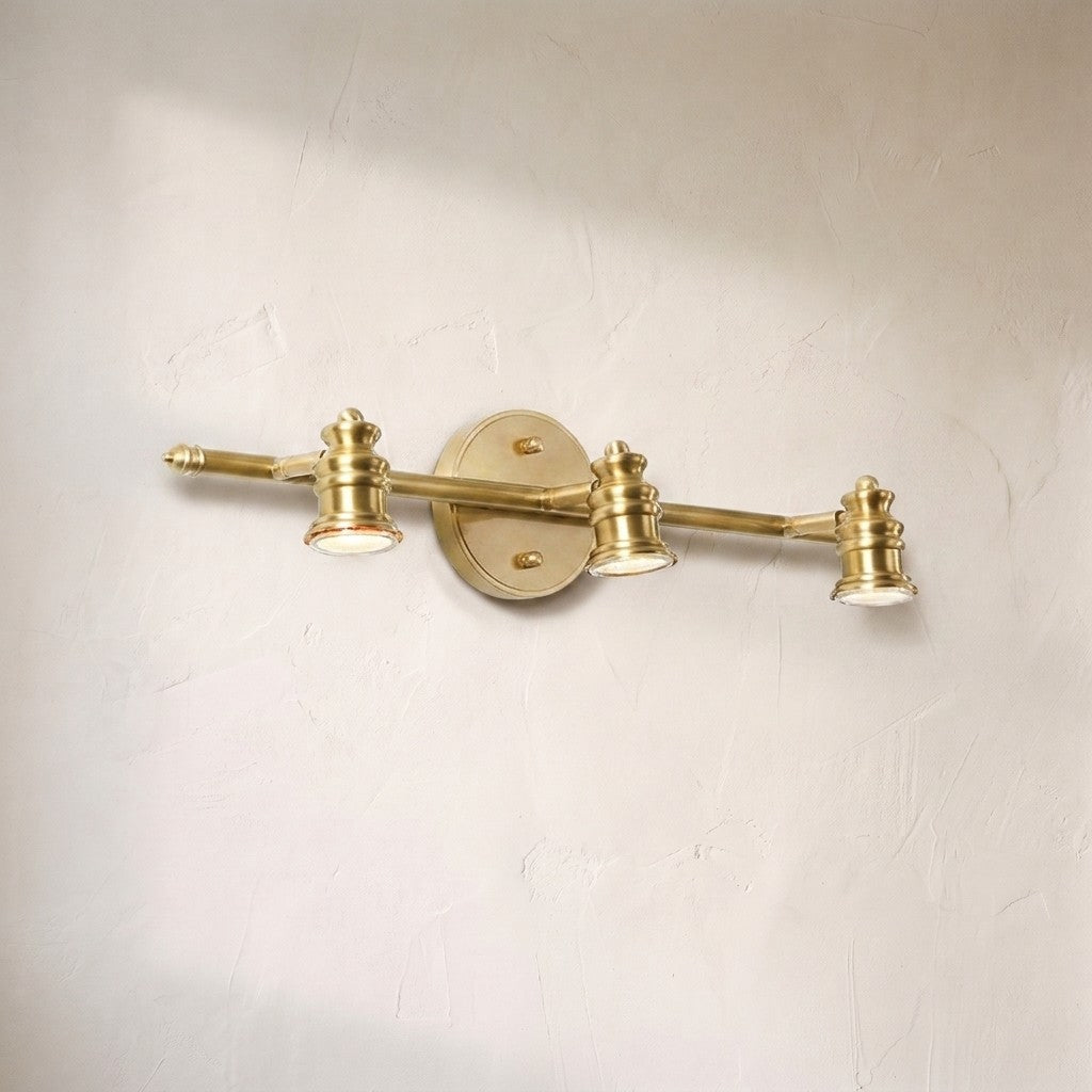 Halophane brass wall lamp, three adjustable brass spotlight heads on a horizontal bar