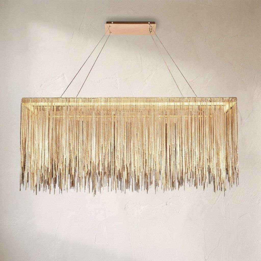 Linear LED chandelier with a curtain of fine brass chain fringe cut to an uneven hem