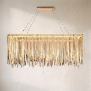 Linear LED chandelier with a curtain of fine brass chain fringe cut to an uneven hem