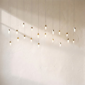 Leo rectangular chandelier, twenty opal glass drops with brass caps hung at staggered heights on slim cords