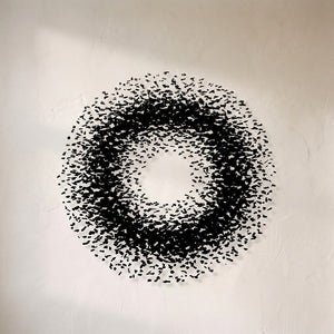The Charcoal Halo chandelier, a dense ring of black stone fragments suspended on fine cables